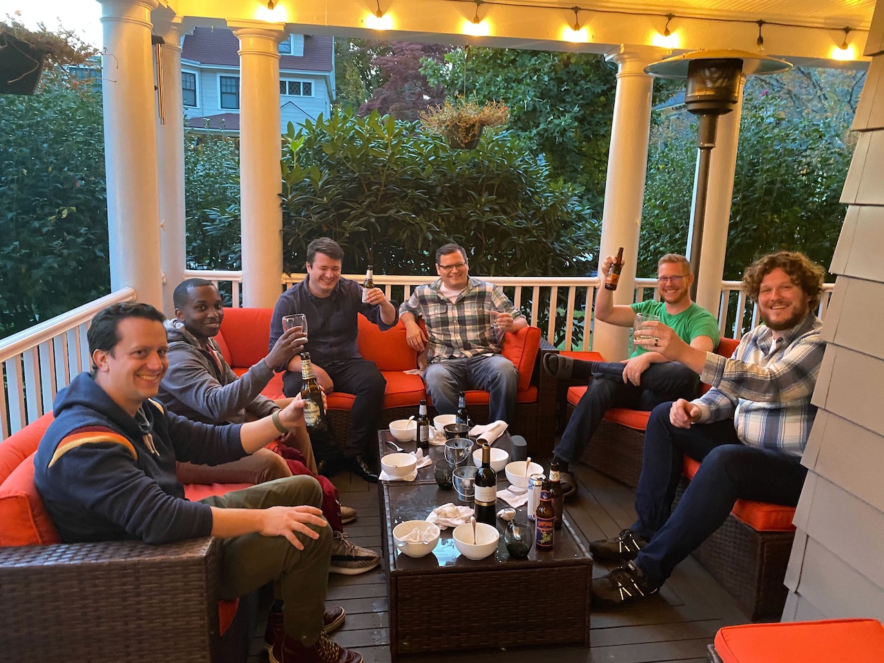 A bunch of dudes sitting on a porch.